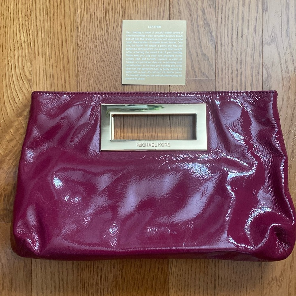 Michael Kors Berkeley burgundy leather clutch handbag.